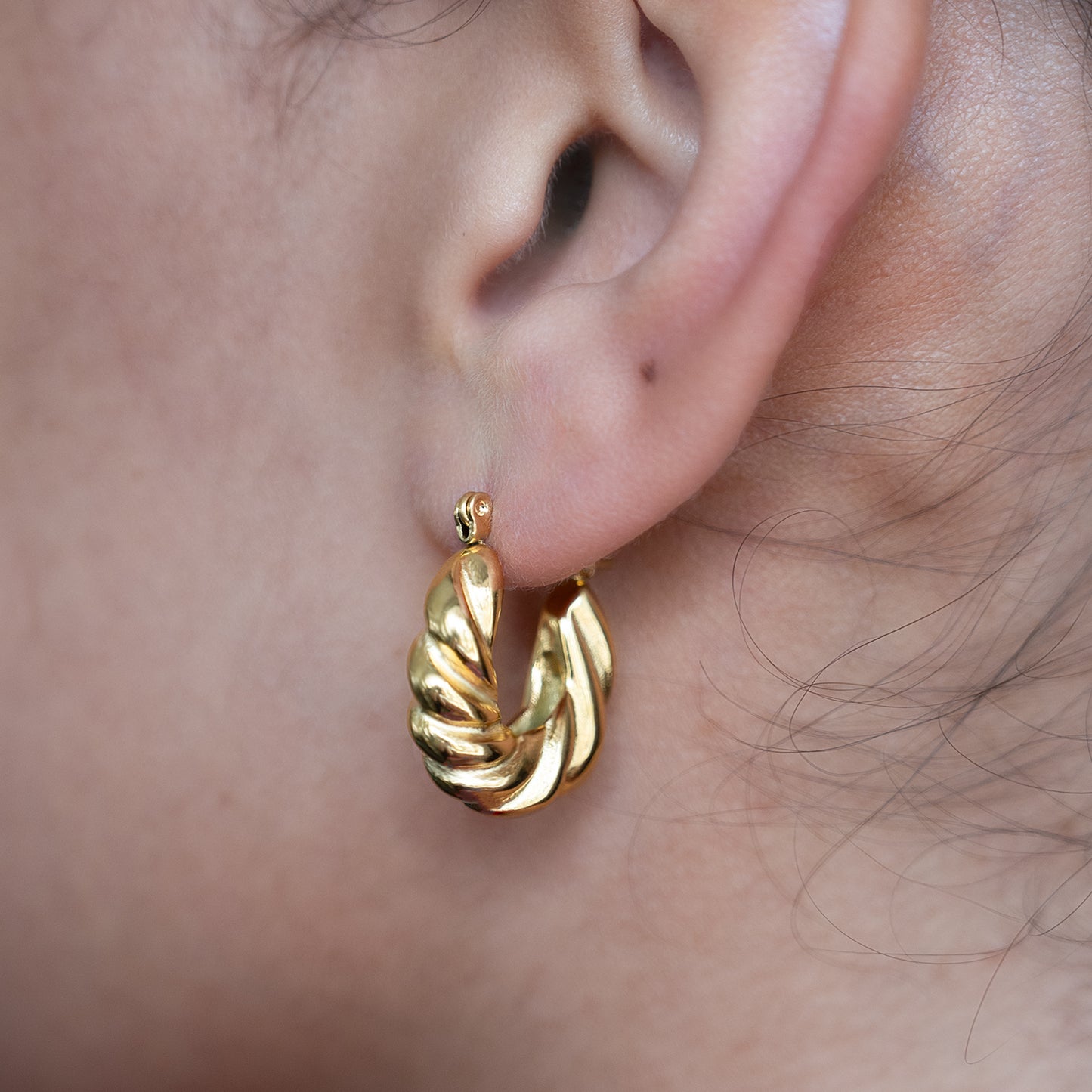 Twisted Croissant Hoop Earrings shown worn in a model's ear