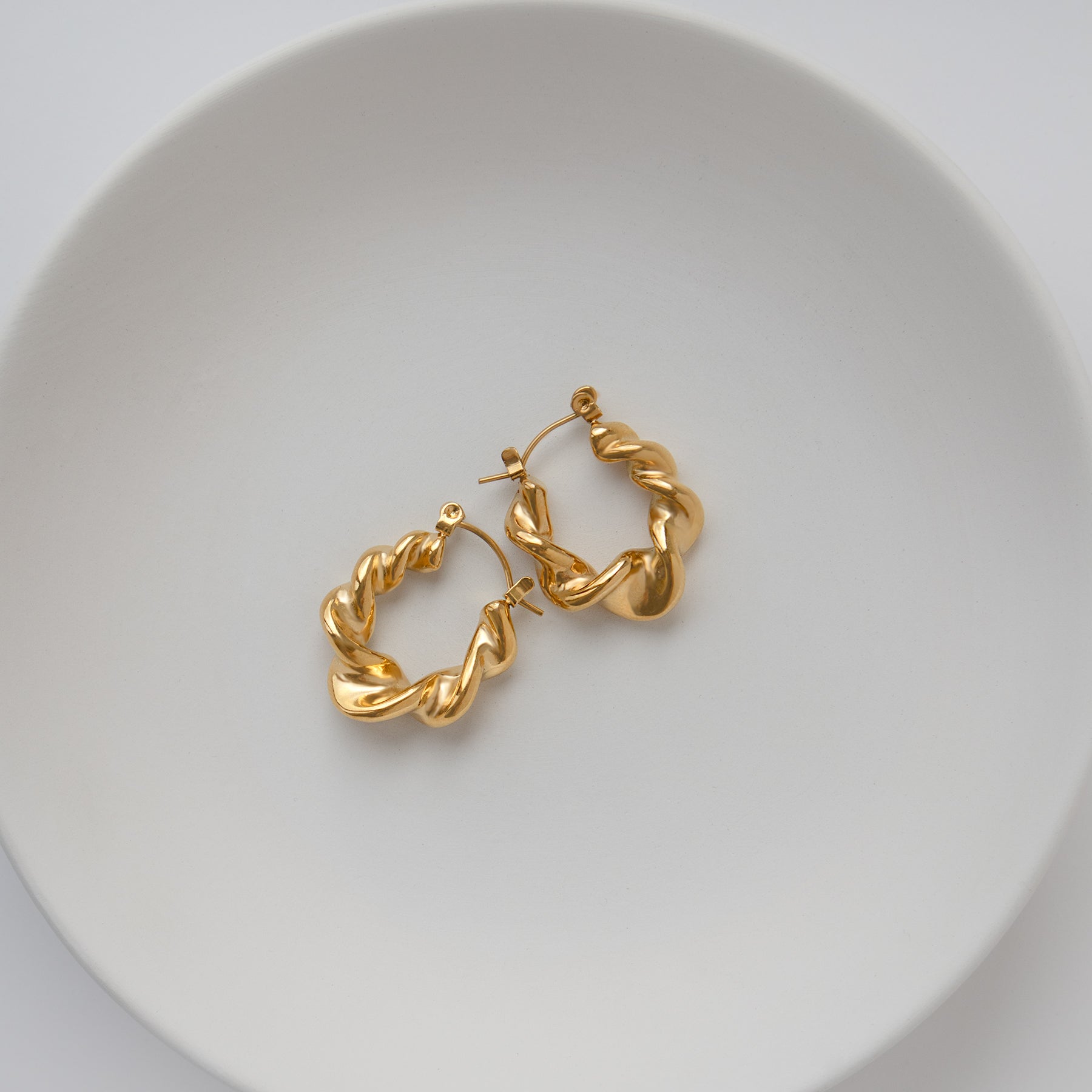 Chunky Twisted Hoop Earrings Non Tarnish displayed in a white dish