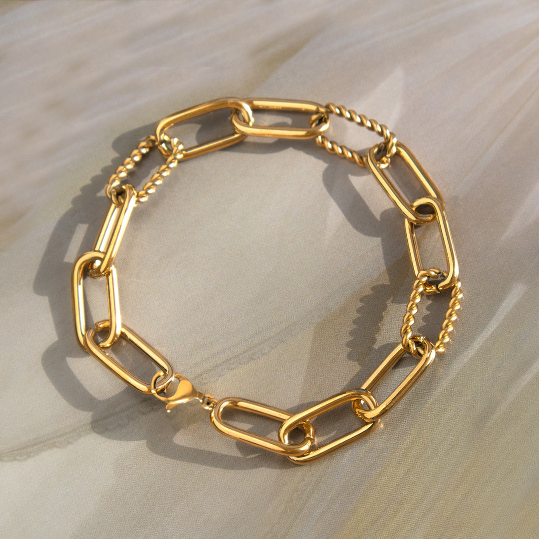 Gold chain bracelet on a light wooden surface