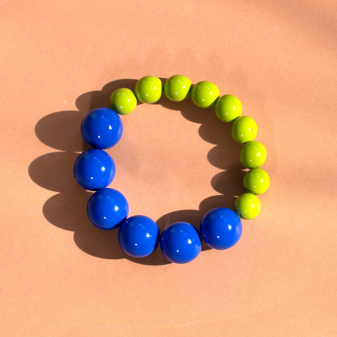 Bracelet with blue and green beads on a peach background