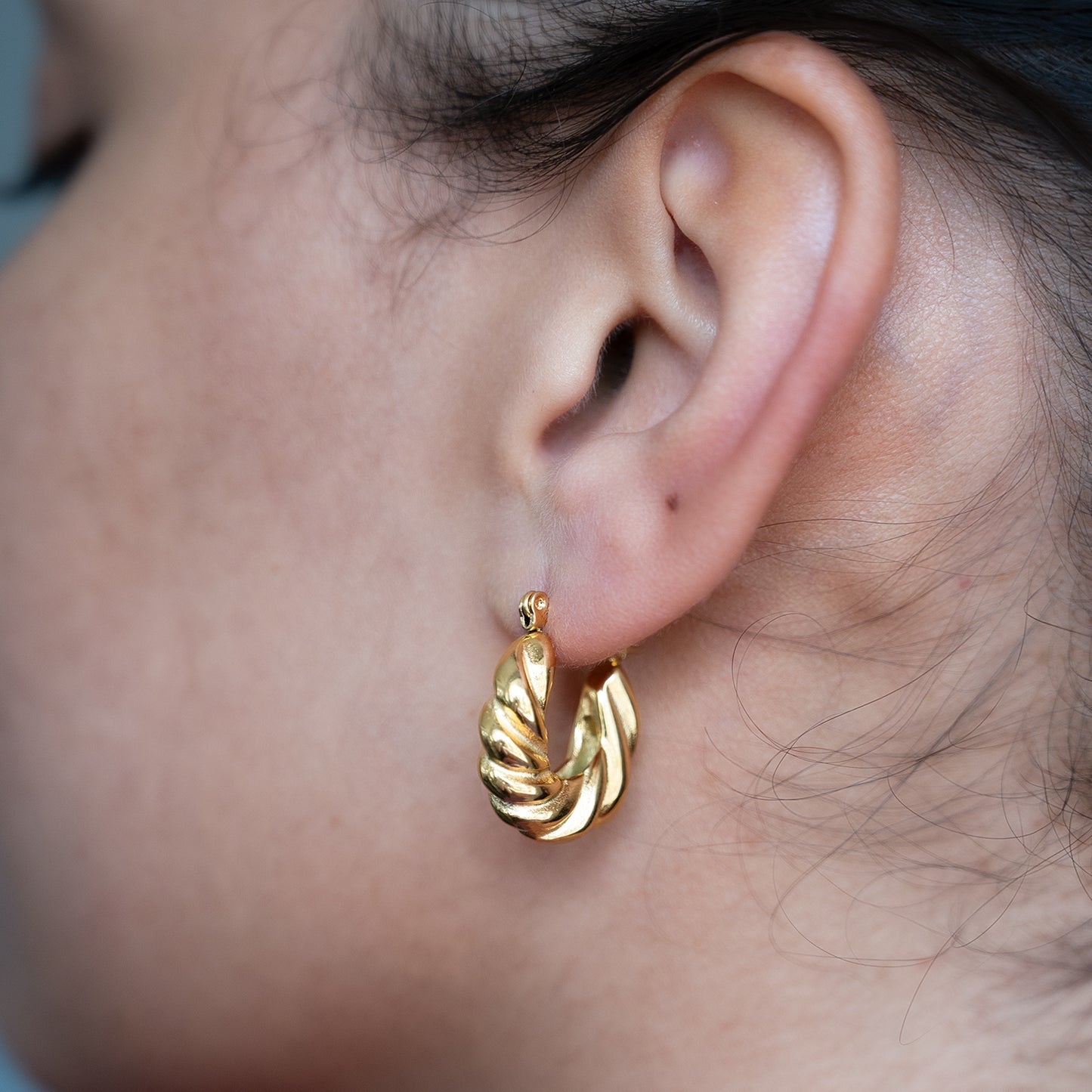 Twisted Croissant Hoop Earrings shown worn in a model's ear
