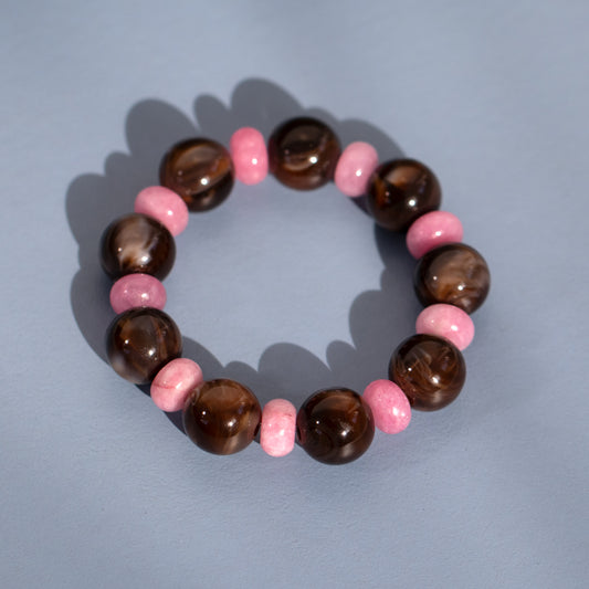 Bracelet with brown and pink beads on a light blue background