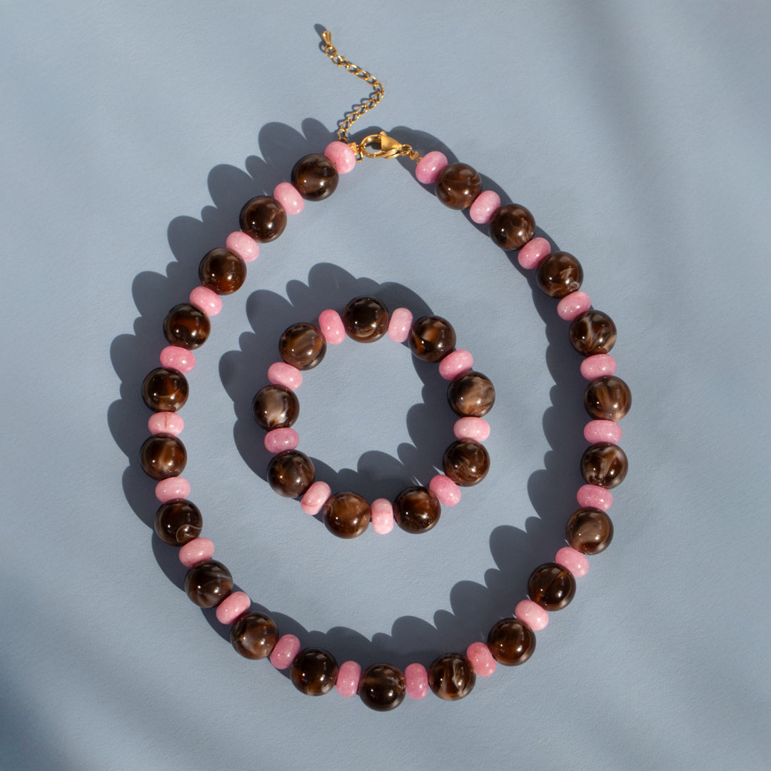 Necklace with pink and brown beads on a light blue background