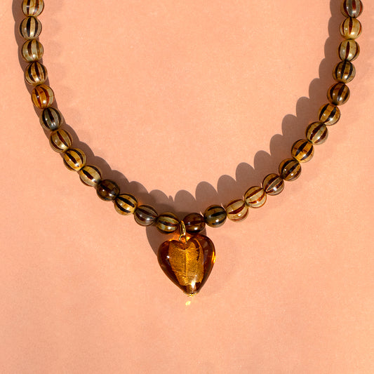 Amber Heart and Stripe Bead Necklace on pink background