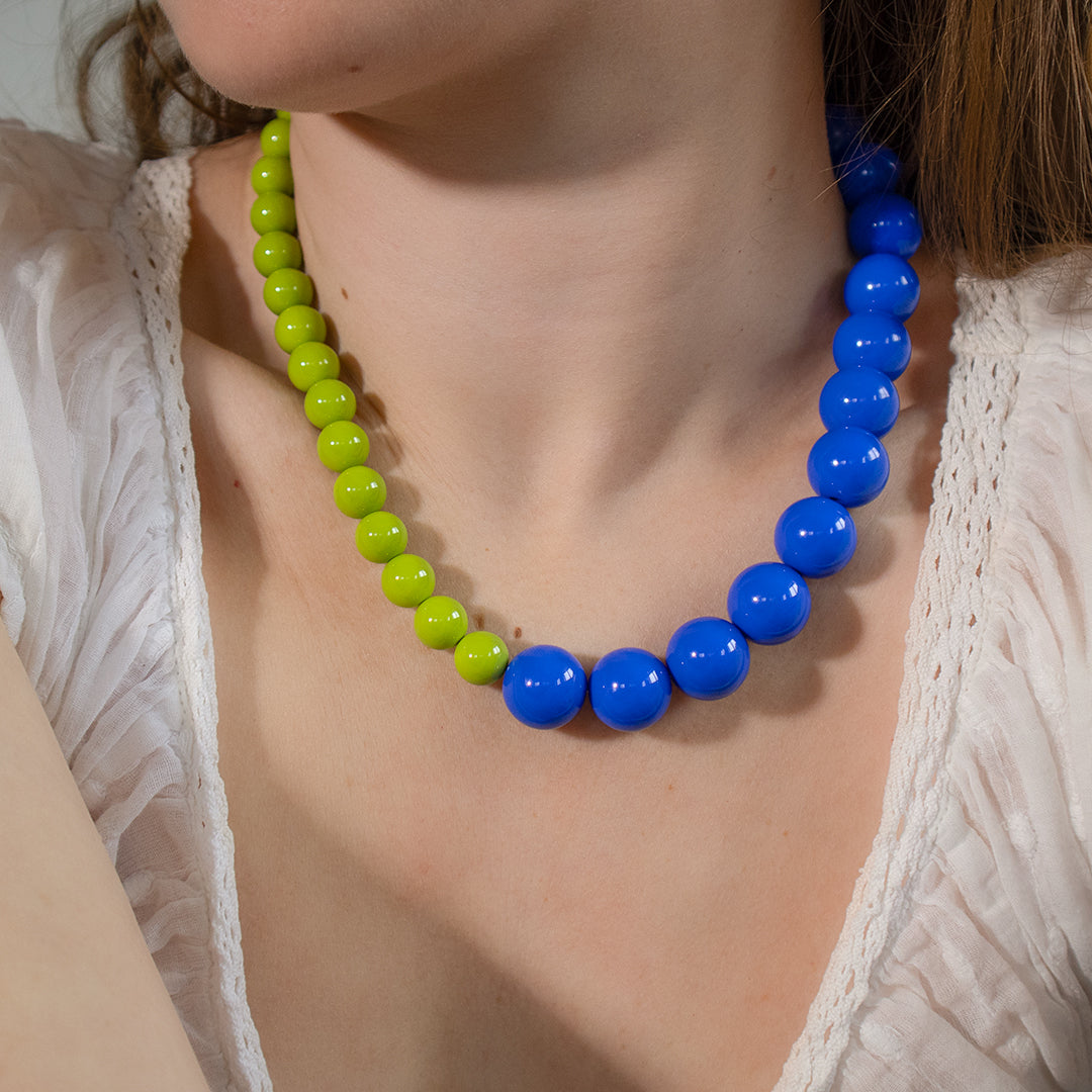 Necklace with blue and green beads worn by a person